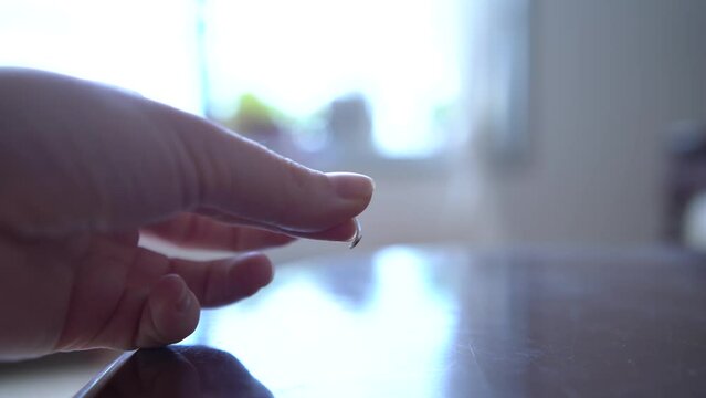 A woman holding a cat's claw that was found in the house, In the background In the background is a large living room window