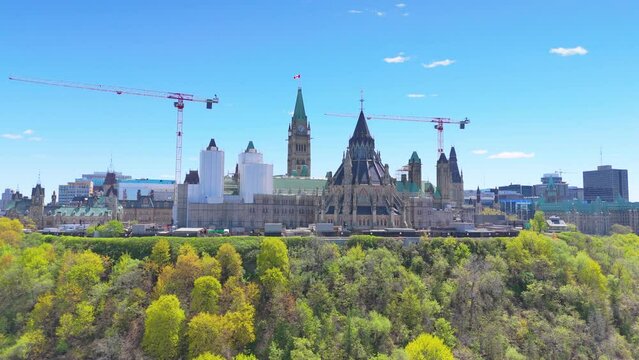 Aerial autumn footage of the historic building of Parliament Hill over Ottawa with beautiful trees