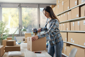 Warehouse worker taping a cardboard delivery box