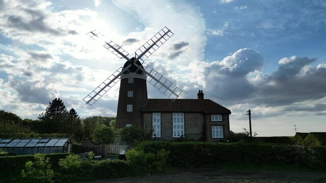 Drone shot of a windmill in Weybourne during a sunny day with clouds on the background.