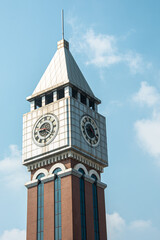 White and red clock tower with a partially cloudy sky behind