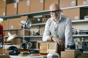 Senior seller smiling and posing in his shop