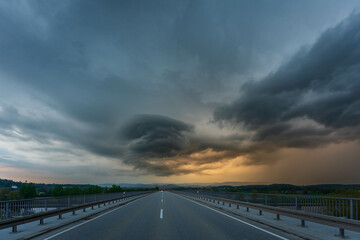 Scenic view of dramatic storm cloud over highway at sunset
