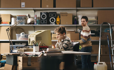 Child using an old computer in the garage