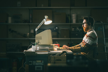 Smart nerd man working with an old PC at night