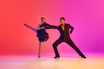 Pair of dancers embody art of ballroom dance, perform their refined movements in neon lighting...