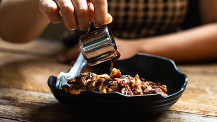 Pour the sauce onto the roasted chicken rice plate and place the roasted chicken on top of the rice.