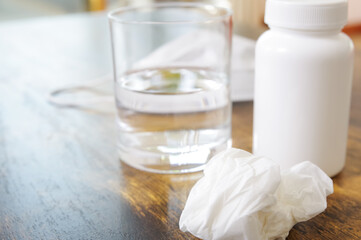 テーブルの上に置いてある薬とコップ