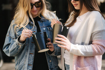 Female friends buy asian food. Girls open boxes and use food sticks. Takeaway food concept