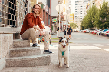 Young Caucasian bearded man posing with purebred Aussie dog. Pet training and friendship with dog....