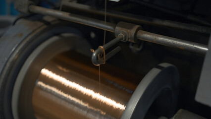 Close-up of coil winding copper wire. Creative. Shiny copper wire is wound on coil at metallurgical...