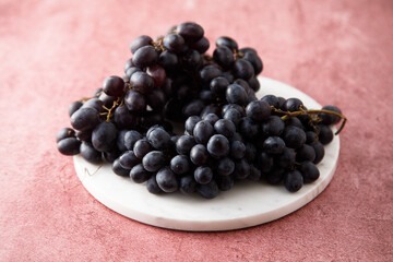 Dark grape on a white desk