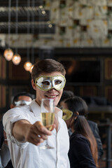 Young man toasting with clinking champagne glasses at funny and happy Christmas and new year party...