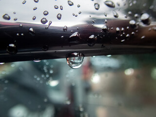 Selective focus water droplets on car windshield with small dust stains