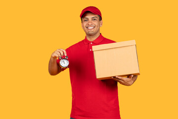 A cheerful delivery man in a red uniform and cap is holding a cardboard box in one hand and an...