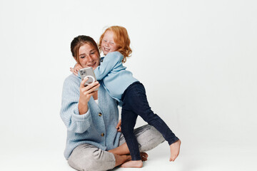 Family time mother and daughter enjoying technology together at home on the floor