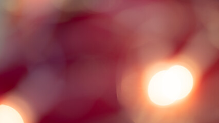 Golden and red bokeh lights create a soft, dreamy background