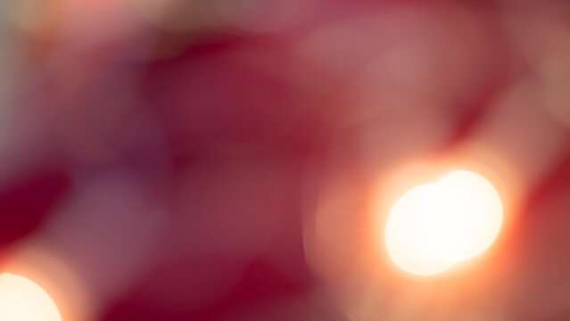Golden and red bokeh lights create a soft, dreamy background