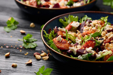 Warm baked carrots and beetroot salad with feta cheese and roasted hazelnuts