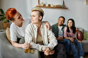 Diverse group of friends, including a loving lesbian couple, enjoy relaxing together on top of a couch.