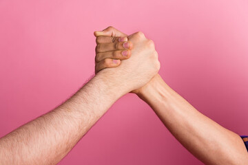 Photo of two people hold hands fist unity team greeting together strong concept isolated pastel...