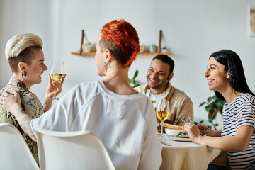 Diverse group enjoys wine and conversation around table.