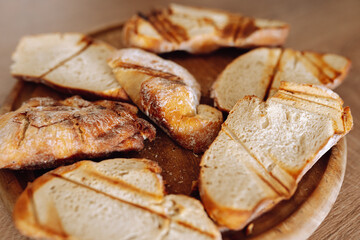 dried wheat bread, croutons, pieces, on a wooden round board