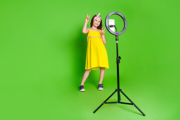 Full length photo of girlish pretty little lady dressed yellow outfit showing v-signs recording...