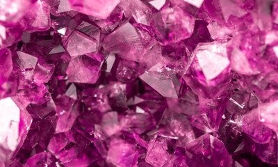 Fototapeta premium Amethyst pink crystals. Gems. Mineral crystals in the natural environment. Texture of precious and semiprecious stones. Seamless background with copy space colored shiny surface of precious stones.