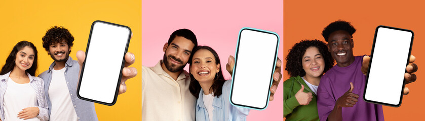 Diverse young couples showing smartphones with white blank screens, posing on colorful background,...