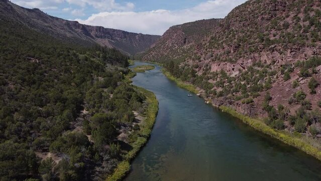 Aerial tilt-down view of green river in Utah with fishing boat