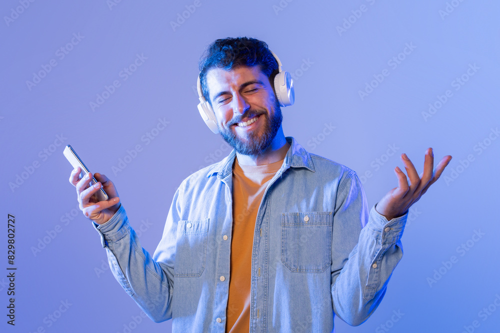 Poster a man with headphones on his ears is seen holding a cell phone in his hand. he seems focused on the 