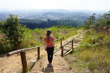 Young hiker woman walks Trilha do Pai Ze path in Jaragua State Park in Sao Paulo, Brazil