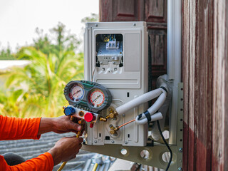 Air conditioning technicians install new compressor air  using monitor tool to check air...