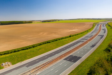 Fototapeta premium Aerial photo of the M1 motorway located in the city of Leeds in West Yorkshire UK, showing the motorway with no traffic in the spring time with fields at the side