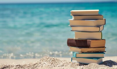 stack of books on the beach with clear blue water background