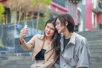 Fototapeta premium Asian couples playfully bond, sharing affectionate gazes, laughter, and intimate warmth outdoors.
