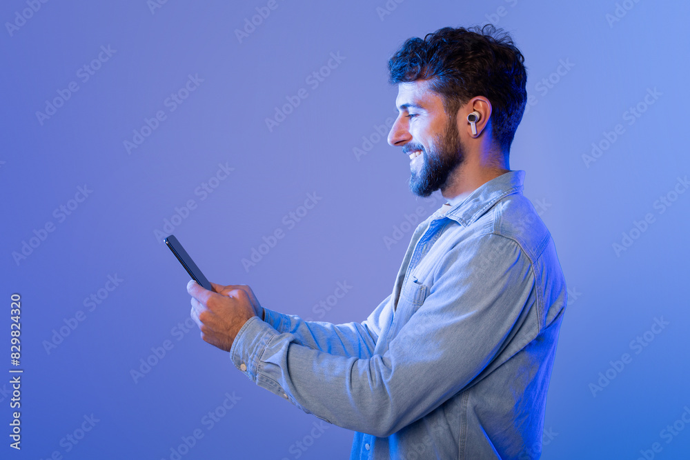 Poster a man is seen holding a cell phone in his hand, looking at the screen. he appears focused on the dev