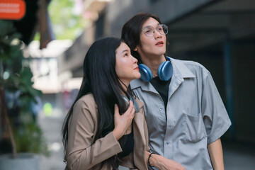 Asian couples playfully bond, sharing affectionate gazes, laughter, and intimate warmth outdoors.