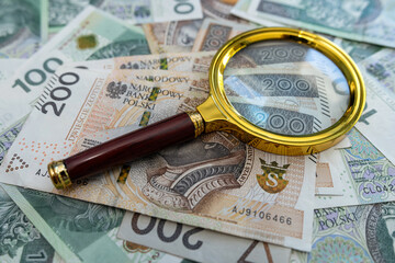 Magnifying Glass with polish money zloty. Business economic concept