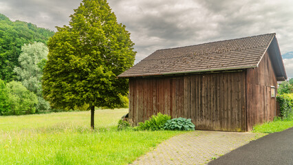 Wiejska zabudowa. Drewniana szopa na nrzedzia. Skosny dach. Budynek przy drodze.  © ff25