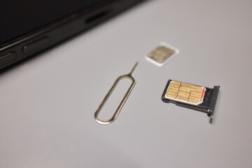A person is inserting a sim card into a cell phone using hand and fingers