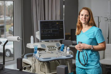 Сardiologist doctor in her office near a medical devices. A rehabilitation doctor in a medical center near modern medical devices waiting for a patient. Professional private clinic.