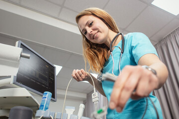 A cardiologist is doing a procedure to check the heart. Cardiologist put electrocardiogram equipment on patient chest and do cardiogram test.