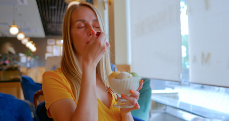 Young woman eating ice cream in a cafe