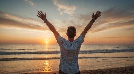 Fototapeta premium A joyful man raising his arms while enjoying the sunset at the beach.