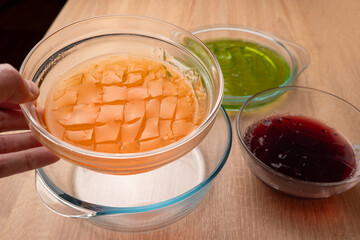The solidified tinted gelatin is cut into cubes. Preparation of gelatin desserts.