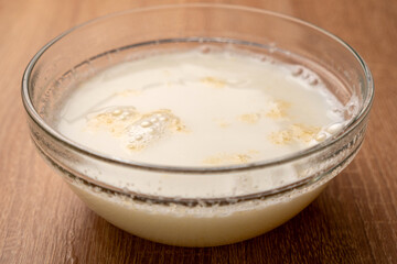 Pour hot milk into a bowl and dissolve gelatin with yogurt.  Preparation of gelatin desserts.