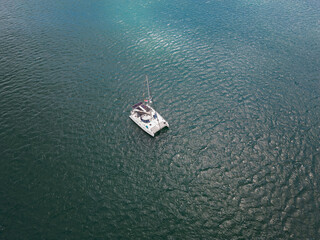A yacht with solar panels sails in the Atlantic Ocean on a spring day, drone point of view.