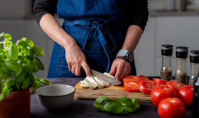 Preparing Caprese Salad, Female Hands Cut Mozzarella Cheese On A Board, With Mozzarella, Basil, And...